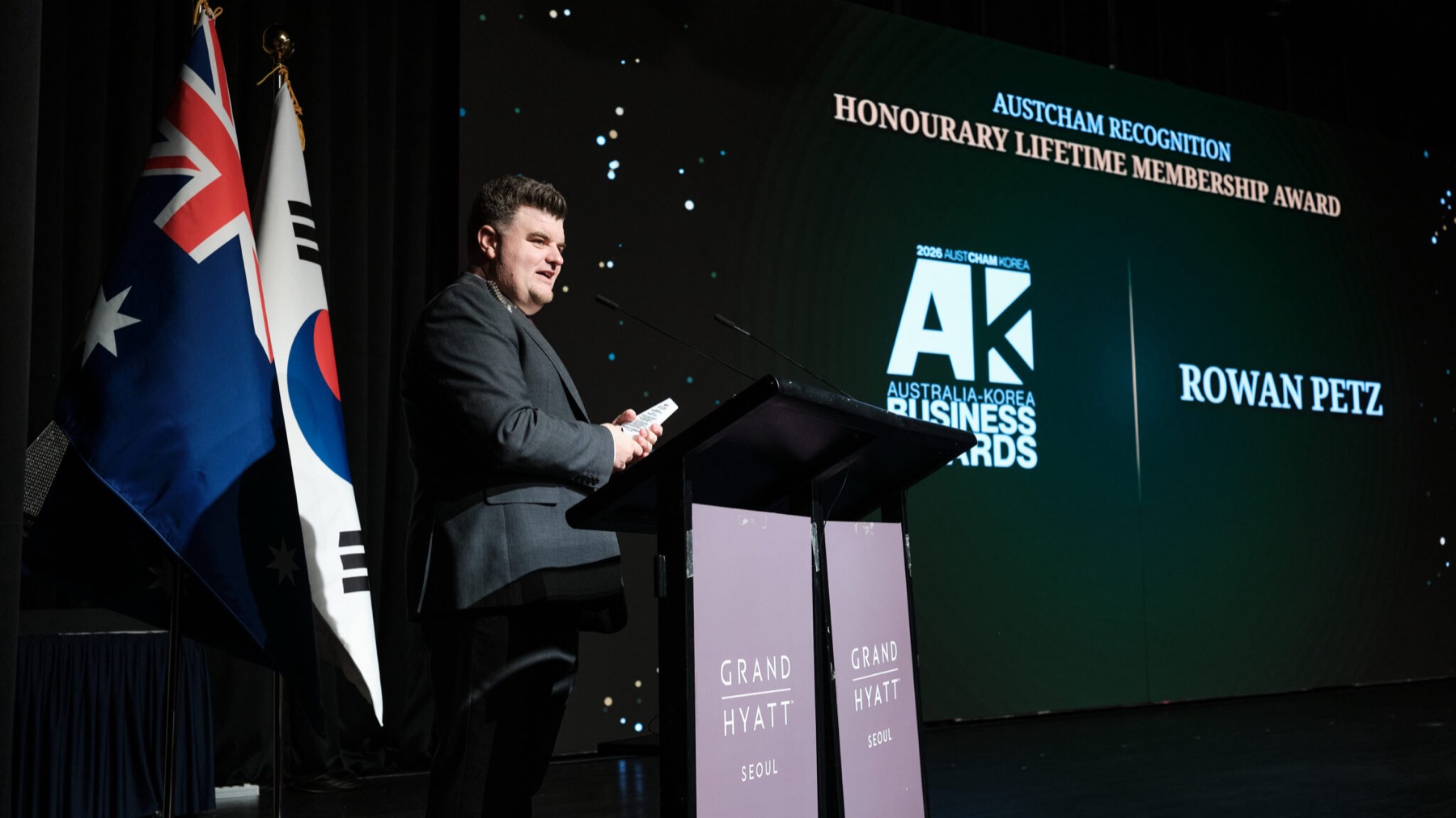 Rowan Petz receiving AustCham’s Honourary Lifetime Membership Award on stage